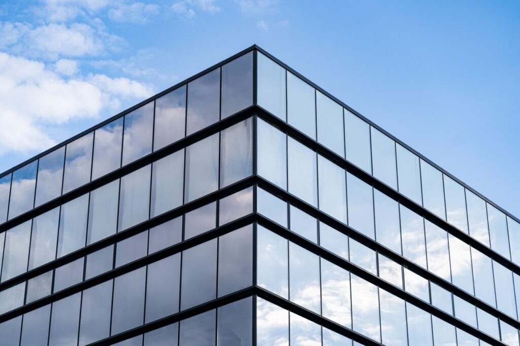 modern glass building architecture with blue sky clouds
