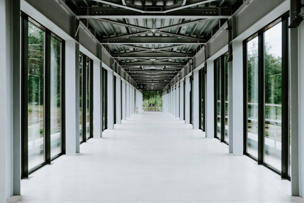 white hallway with glass doors metal ceiling modern building